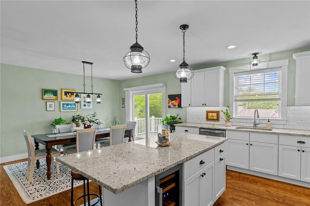 83 Silas Hill Way, Exeter, RI 02822 - kitchen with wine cooler, dark wood finished floors, tasteful backsplash, white cabinetry, and a breakfast bar