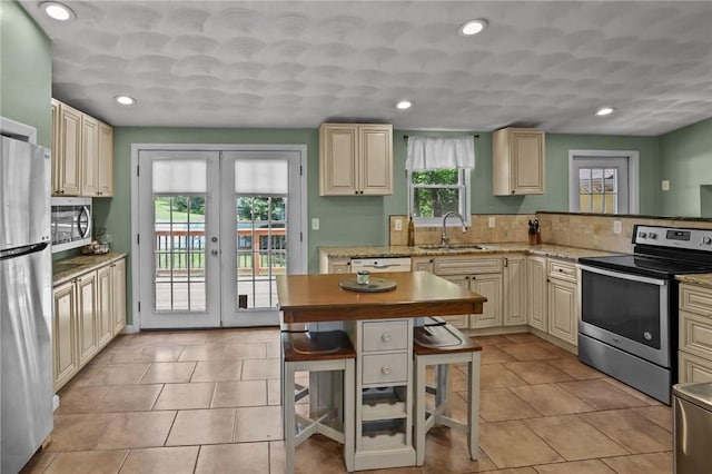 273 Main St, Cranston, RI 02823 - kitchen featuring stainless steel appliances, french doors, a breakfast bar, recessed lighting, and cream cabinetry