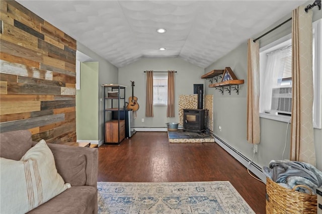 273 Main St, Cranston, RI 02823 - living area with a wood stove, wood finished floors, vaulted ceiling, a baseboard radiator, and cooling unit