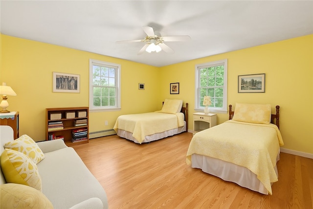 34 Finch Ln, North Kingstown, RI 02874 - bedroom featuring baseboard heating, multiple windows, light wood-style floors, and a ceiling fan