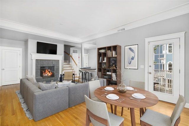 279 Benefit St Unit 3, Providence, RI 02903 - dining area featuring a tile fireplace, light wood-type flooring, and ornamental molding