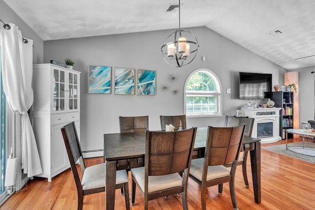 1060 Joslin Rd, Burrillville, RI 02830 - dining space with vaulted ceiling, light wood-style floors, baseboard heating, a chandelier, and a glass covered fireplace