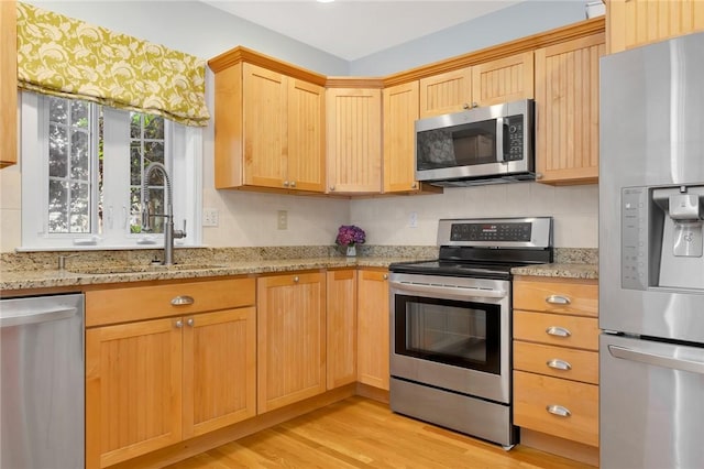1 Slocum St, Newport, RI 02840 - kitchen with appliances with stainless steel finishes, light wood finished floors, light brown cabinets, light stone counters, and decorative backsplash