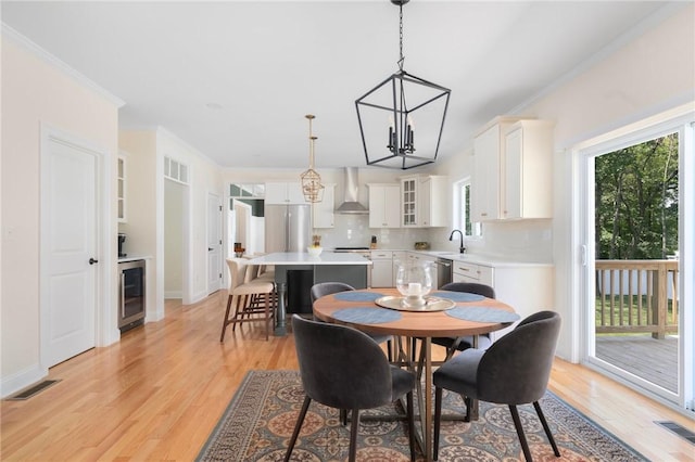 9 Scarlett Way, Cranston, RI 02921 - dining space featuring beverage cooler, a chandelier, light wood-type flooring, and crown molding
