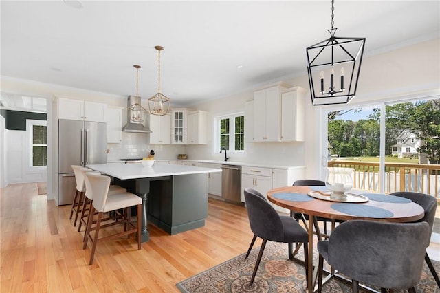 9 Scarlett Way, Cranston, RI 02921 - kitchen with stainless steel appliances, wall chimney exhaust hood, a kitchen island, light wood-style floors, and light countertops