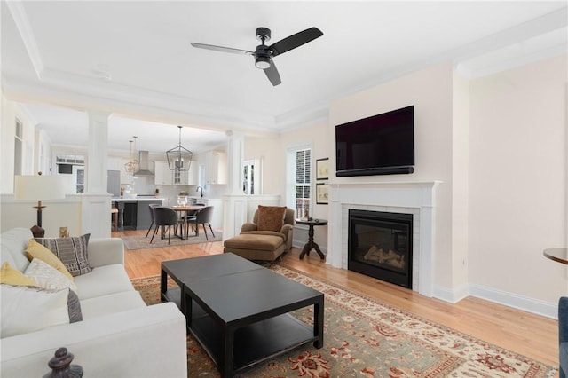 9 Scarlett Way, Cranston, RI 02921 - living area with ceiling fan, light wood finished floors, ornamental molding, decorative columns, and a glass covered fireplace