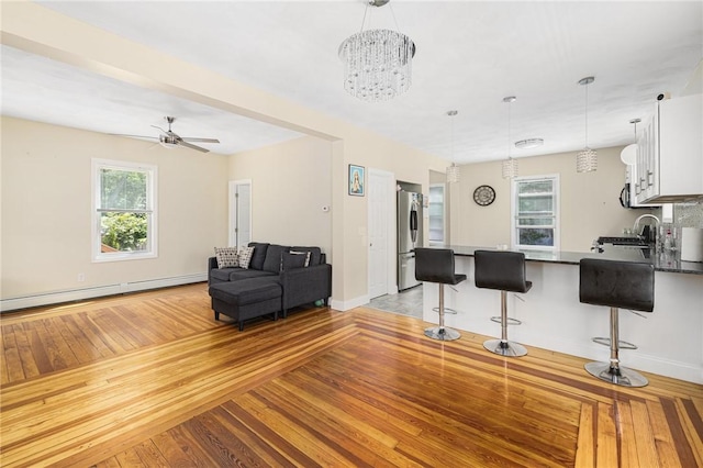 2 Palfrey Pl, Providence, RI 02909 - living area featuring a baseboard radiator, light wood finished floors, ceiling fan, and a chandelier
