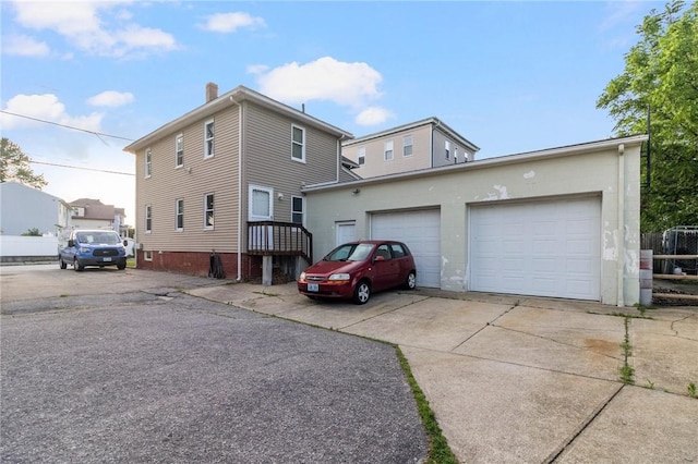 598 Laurel Hill Ave, Cranston, RI 02920 - view of side of home with concrete driveway, a chimney, and an attached garage