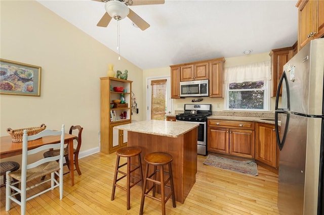 104 Conanicus Rd, Narragansett, RI 02882 - kitchen with stainless steel appliances, light wood-type flooring, a kitchen island, lofted ceiling, and a ceiling fan