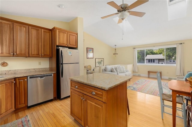 104 Conanicus Rd, Narragansett, RI 02882 - kitchen with appliances with stainless steel finishes, vaulted ceiling, light wood finished floors, brown cabinets, and light stone countertops
