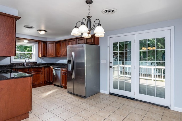 136 Davis Ave, Cranston, RI 02910 - kitchen featuring stainless steel appliances, a chandelier, decorative light fixtures, light tile patterned floors, and dark stone countertops