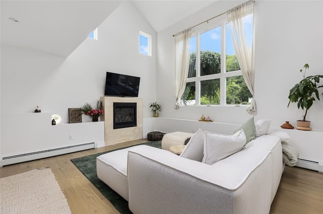 193 Mohawk Trl, Cranston, RI 02921 - living room with baseboard heating, wood finished floors, healthy amount of natural light, high vaulted ceiling, and a tiled fireplace