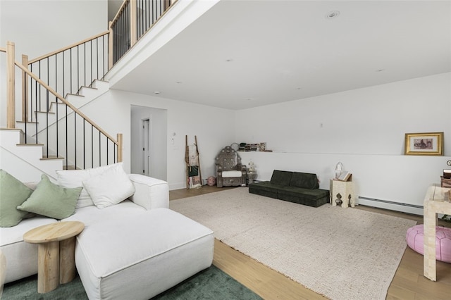 193 Mohawk Trl, Cranston, RI 02921 - living area with a baseboard heating unit, wood finished floors, and stairs