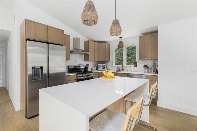 193 Mohawk Trl, Cranston, RI 02921 - kitchen featuring wall chimney range hood, appliances with stainless steel finishes, tasteful backsplash, vaulted ceiling, and light wood-style floors