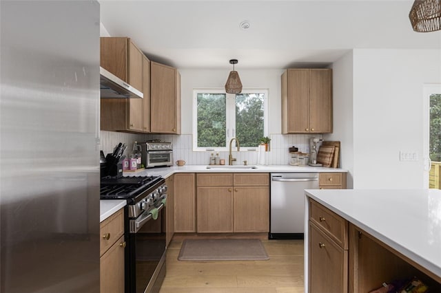 193 Mohawk Trl, Cranston, RI 02921 - kitchen with stainless steel appliances, under cabinet range hood, light wood finished floors, light countertops, and tasteful backsplash