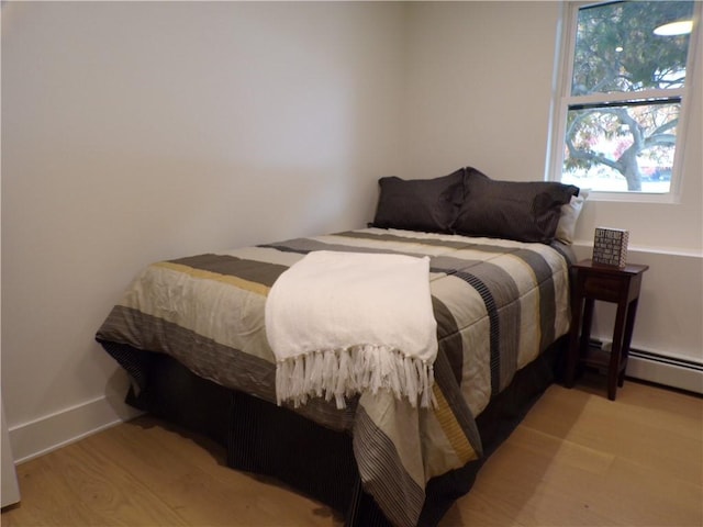 193 Mohawk Trl, Cranston, RI 02921 - bedroom with multiple windows, a baseboard heating unit, and light wood-type flooring