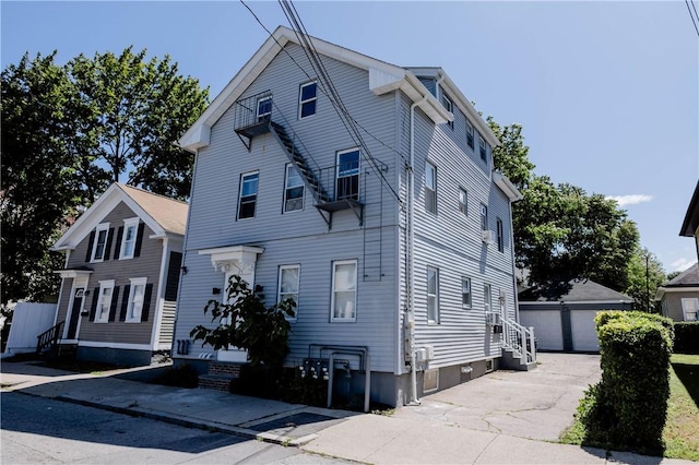 25 Unit St, Providence, RI 02909 - view of front of house with entry steps, an outbuilding, and a garage