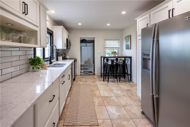 31 Bowen St, East Providence, RI 02916 - kitchen featuring stainless steel fridge, tasteful backsplash, white cabinetry, recessed lighting, and light stone countertops