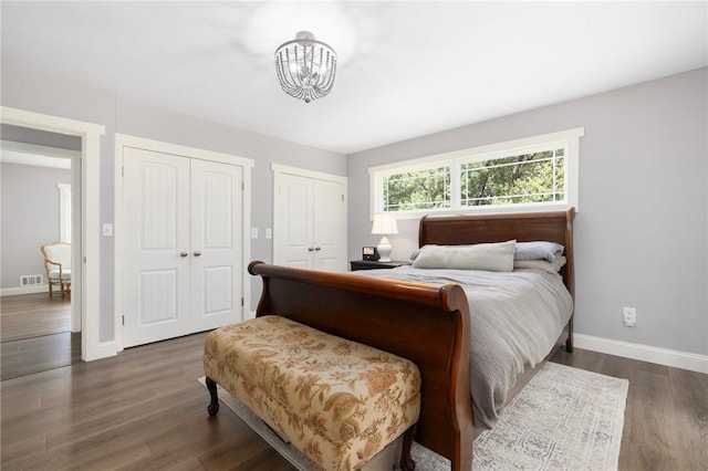 469 Fletcher Rd, North Kingstown, RI 02852 - bedroom with two closets, a chandelier, and dark wood-style floors