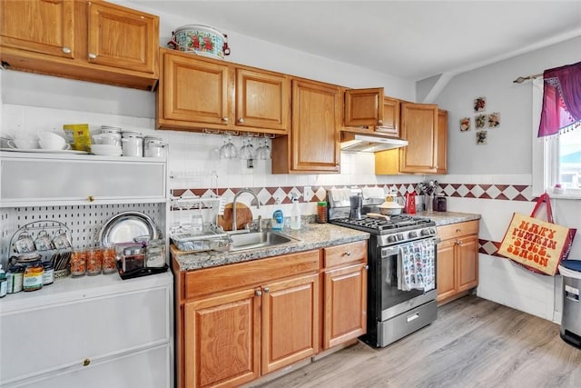 222 Pavilion Ave, Providence, RI 02905 - kitchen with gas stove, under cabinet range hood, light wood-type flooring, tasteful backsplash, and brown cabinets