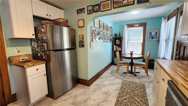 788 Cass Ave, Woonsocket, RI 02895 - kitchen with wood counters, stainless steel appliances, arched walkways, light marble finish flooring, and white cabinets