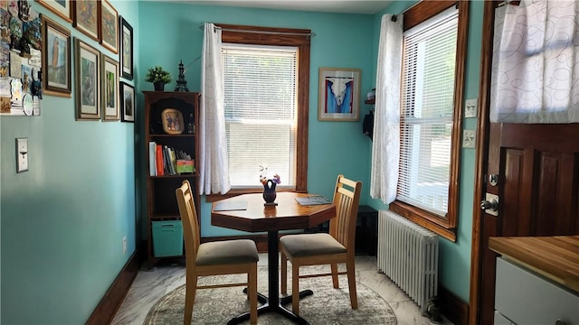 788 Cass Ave, Woonsocket, RI 02895 - dining space featuring radiator, plenty of natural light, and light marble finish floors