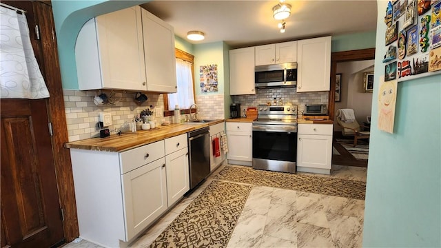 788 Cass Ave, Woonsocket, RI 02895 - kitchen with appliances with stainless steel finishes, wood counters, tasteful backsplash, and white cabinets