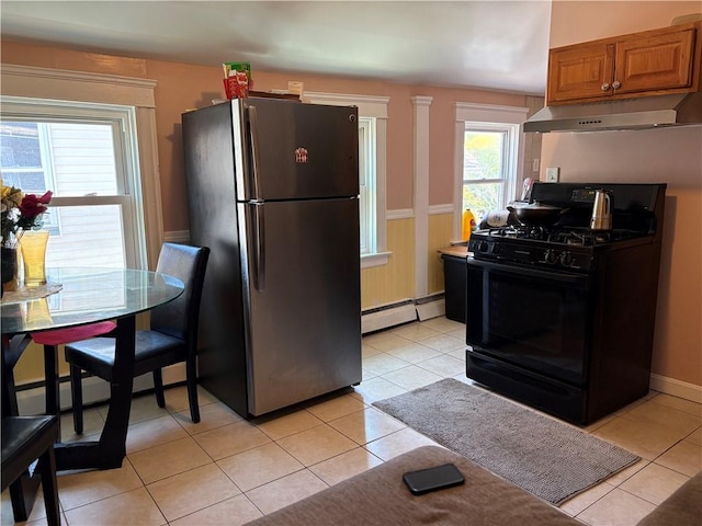 282 Oxford St, Providence, RI 02905 - kitchen featuring freestanding refrigerator, gas stove, under cabinet range hood, a baseboard radiator, and light tile patterned flooring
