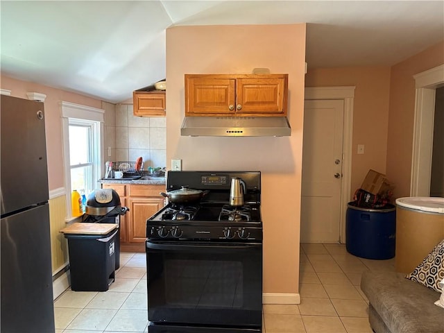 282 Oxford St, Providence, RI 02905 - kitchen featuring black range with gas cooktop, freestanding refrigerator, under cabinet range hood, light tile patterned floors, and lofted ceiling