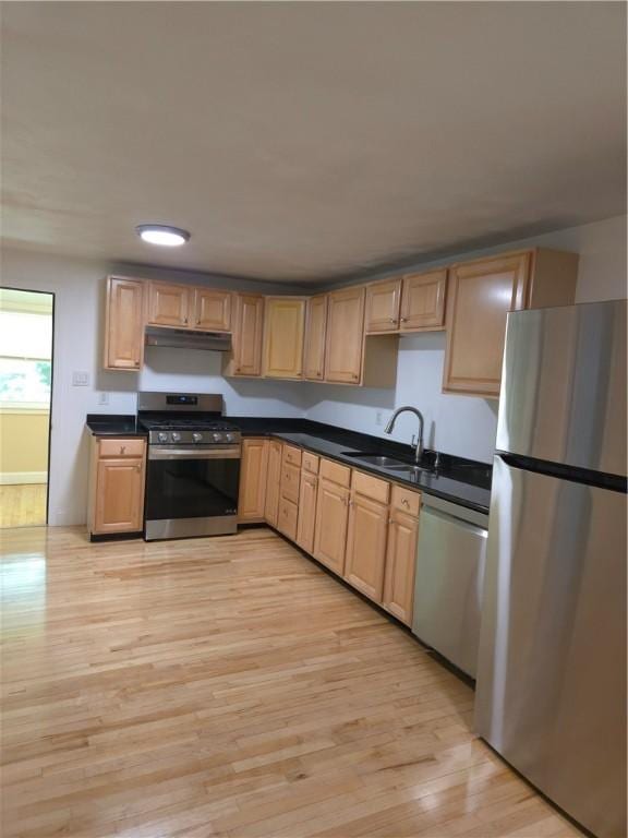 7 Edge St, West Warwick, RI 02893 - kitchen featuring appliances with stainless steel finishes, under cabinet range hood, light wood-style flooring, and dark countertops
