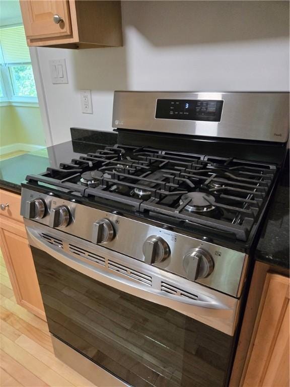 7 Edge St, West Warwick, RI 02893 - kitchen view of stainless steel gas range oven, dark countertops, and light wood finished floors