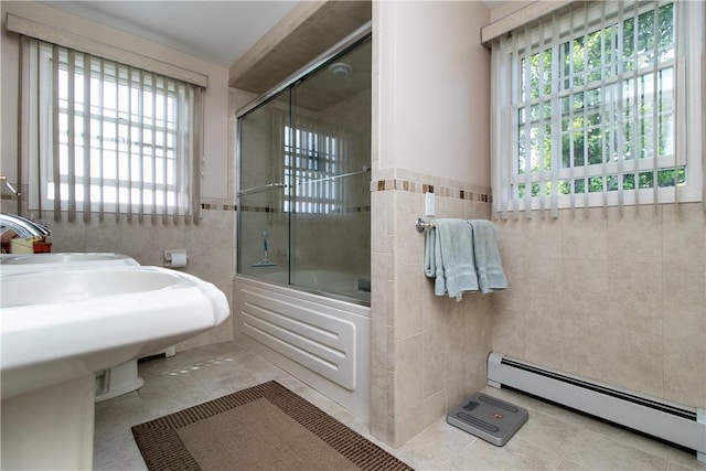 136 Woodward Rd, Providence, RI 02904 - full bath featuring tile walls, a baseboard radiator, tile patterned floors, and combined bath / shower with glass door