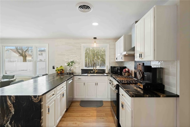 6 Flanders St, Johnston, RI 02919 - kitchen with gas range oven, a peninsula, black microwave, dark countertops, and decorative backsplash