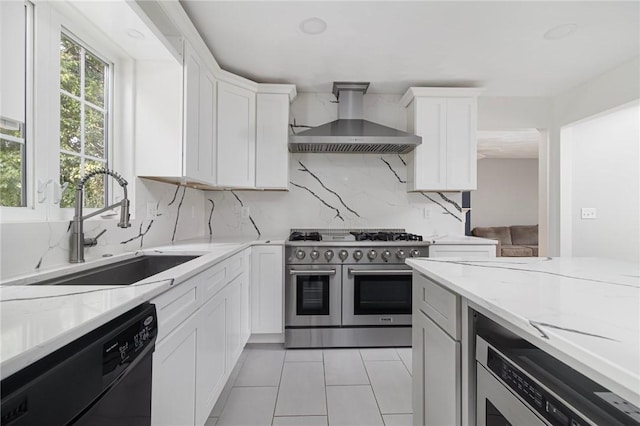 29 Gilcrest Dr, West Warwick, RI 02893 - kitchen featuring wall chimney exhaust hood, range with two ovens, dishwashing machine, light tile patterned flooring, and white cabinets