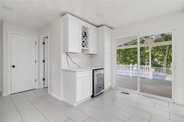 29 Gilcrest Dr, West Warwick, RI 02893 - kitchen with beverage cooler, light tile patterned floors, and white cabinetry