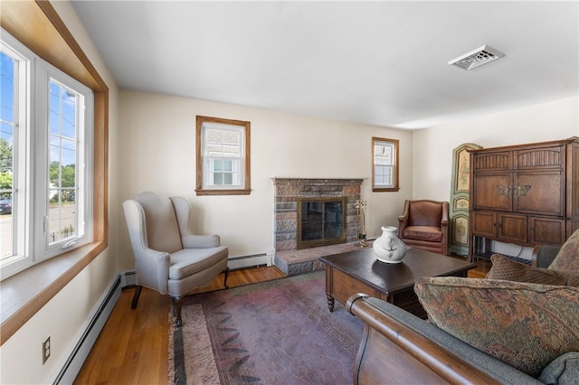 59 Waite St, Providence, RI 02908 - living room featuring baseboard heating, wood finished floors, and a fireplace