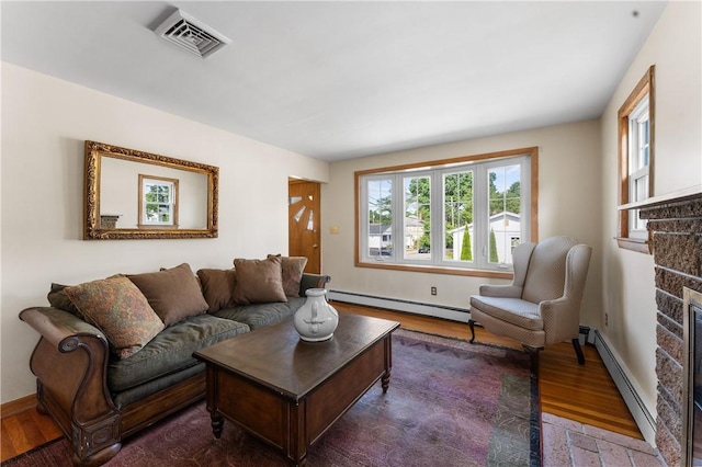 59 Waite St, Providence, RI 02908 - living area with baseboard heating, wood finished floors, and a stone fireplace