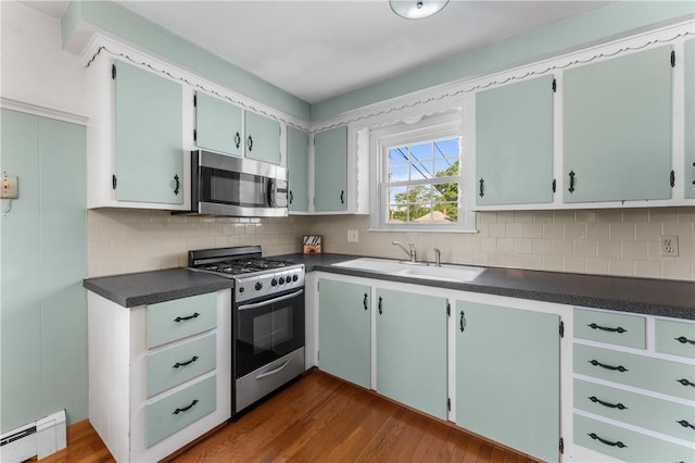 59 Waite St, Providence, RI 02908 - kitchen featuring stainless steel appliances, baseboard heating, dark countertops, and dark wood finished floors