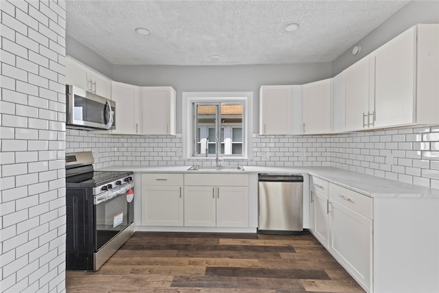 33 Marion Ave, Providence, RI 02905 - kitchen with appliances with stainless steel finishes, a textured ceiling, dark wood finished floors, white cabinets, and light countertops