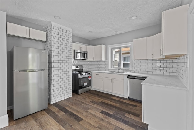 33 Marion Ave, Providence, RI 02905 - kitchen featuring stainless steel appliances, a textured ceiling, dark wood-type flooring, white cabinetry, and decorative backsplash