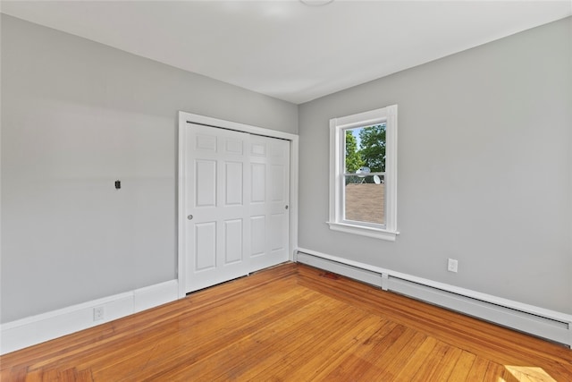 33 Marion Ave, Providence, RI 02905 - unfurnished bedroom featuring a baseboard radiator, a closet, and light wood finished floors