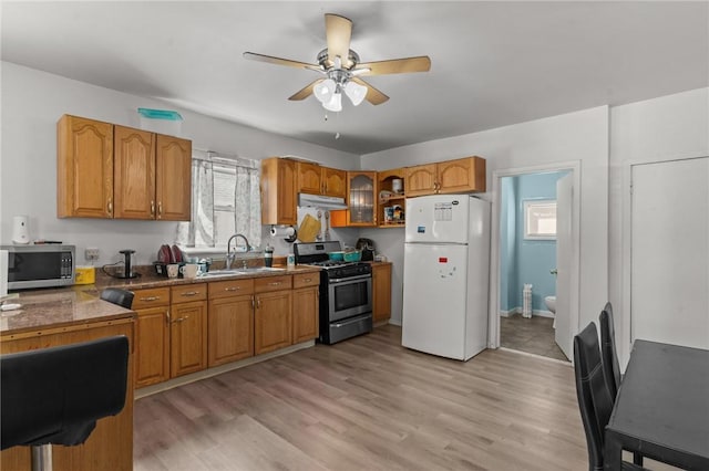 18 Ortoleva Dr, Providence, RI 02909 - kitchen featuring appliances with stainless steel finishes, under cabinet range hood, brown cabinets, a ceiling fan, and healthy amount of natural light