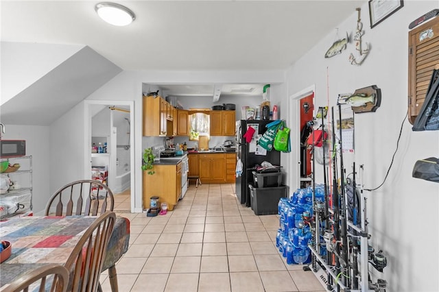 18 Ortoleva Dr, Providence, RI 02909 - kitchen featuring electric range, light tile patterned floors, brown cabinetry, freestanding refrigerator, and dark countertops