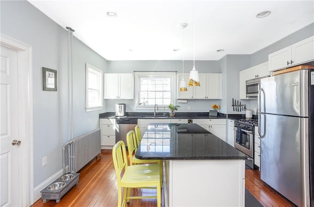 6 Pond Ave, Newport, RI 02840 - kitchen featuring stainless steel appliances, white cabinetry, a kitchen bar, dark wood-type flooring, and recessed lighting