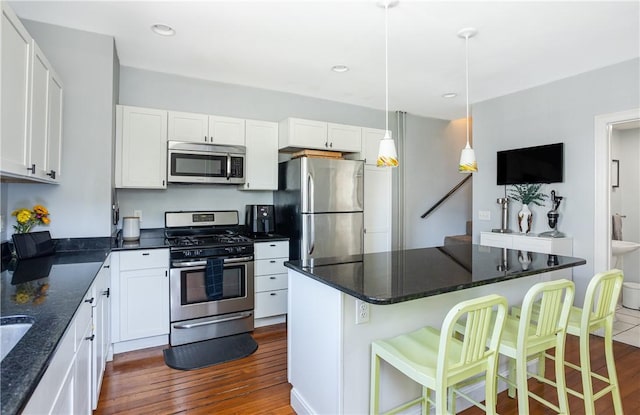 6 Pond Ave, Newport, RI 02840 - kitchen featuring stainless steel appliances, dark wood-type flooring, white cabinetry, a kitchen breakfast bar, and hanging light fixtures
