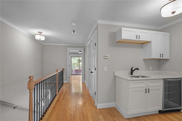 888 Plainfield Pike, Coventry, RI 02827 - corridor with beverage cooler, light wood-type flooring, ornamental molding, and an upstairs landing