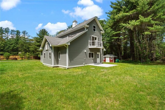 888 Plainfield Pike, Coventry, RI 02827 - back of property featuring a balcony, a chimney, a storage unit, roof with shingles, and a patio area