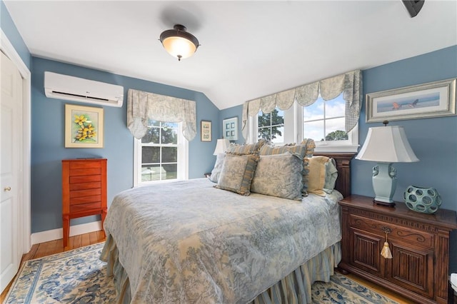 12 Windward Cir, Warwick, RI 02889 - bedroom featuring a wall mounted AC, wood finished floors, a closet, and lofted ceiling