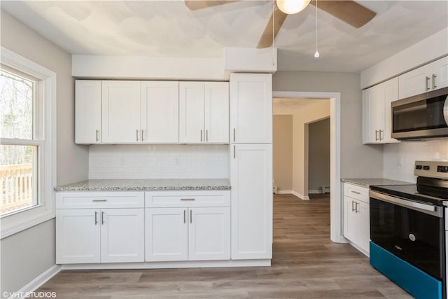 22 T Parker Rd, Foster, RI 02825 - kitchen featuring stainless steel appliances, ceiling fan, white cabinets, and decorative backsplash