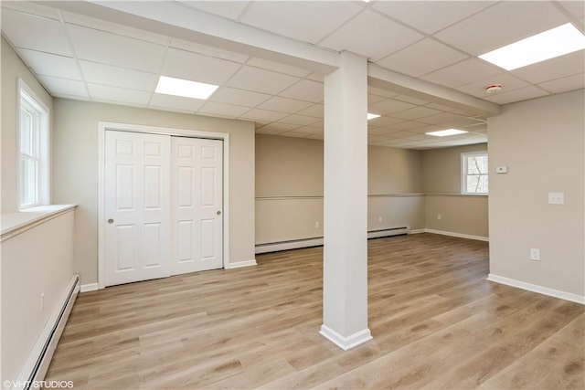 22 T Parker Rd, Foster, RI 02825 - below grade area with baseboard heating, a drop ceiling, a baseboard radiator, and light wood-style flooring